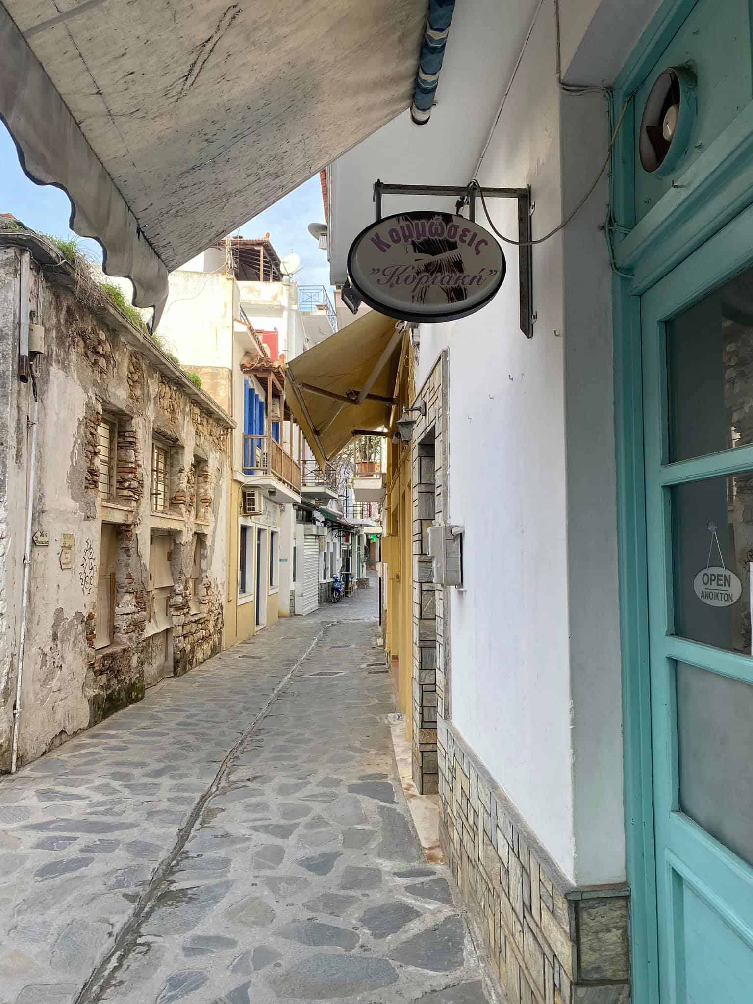 A narrow street featuring a blue door and a sign
