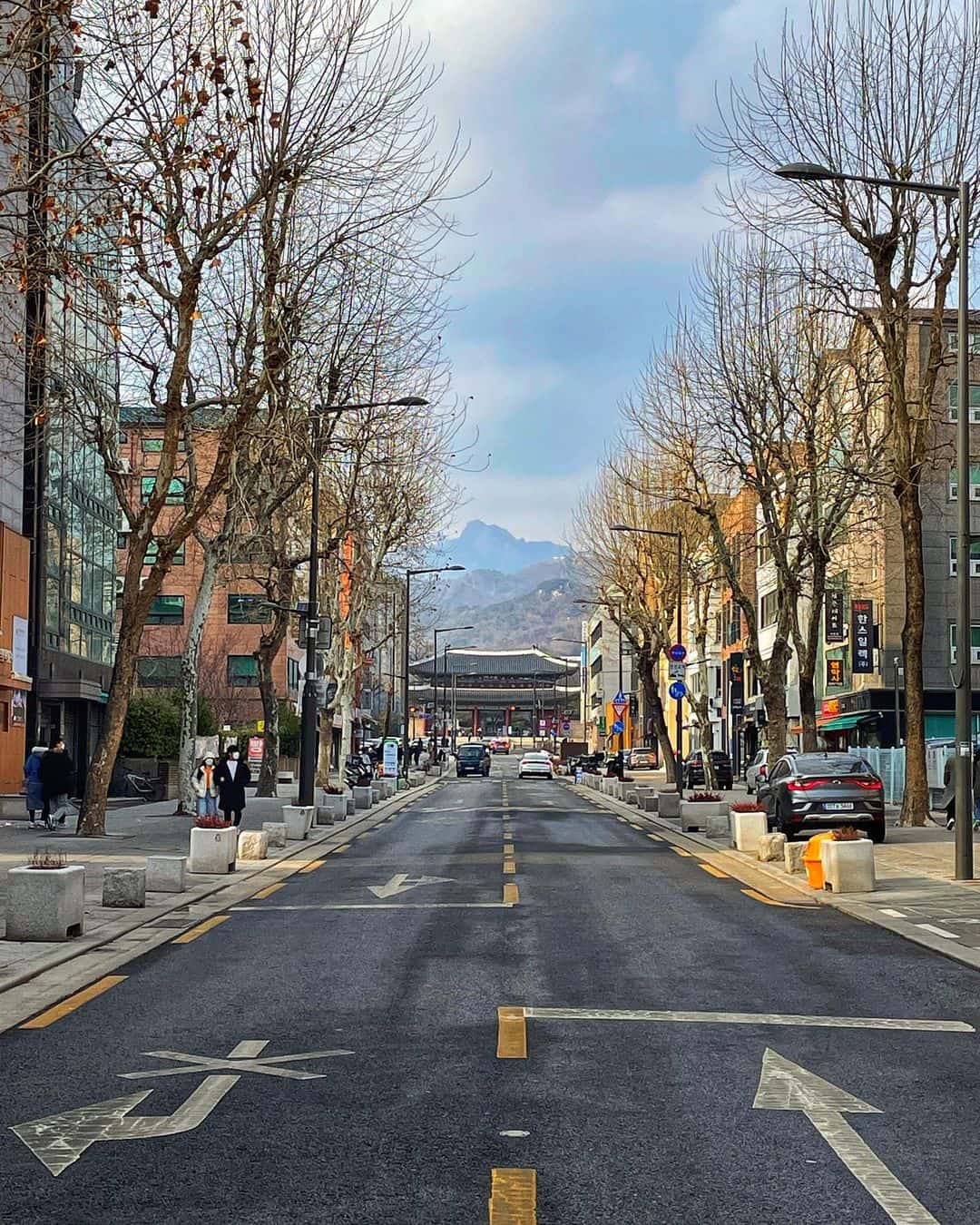 A quiet street in Korea with a mountain rising in the background